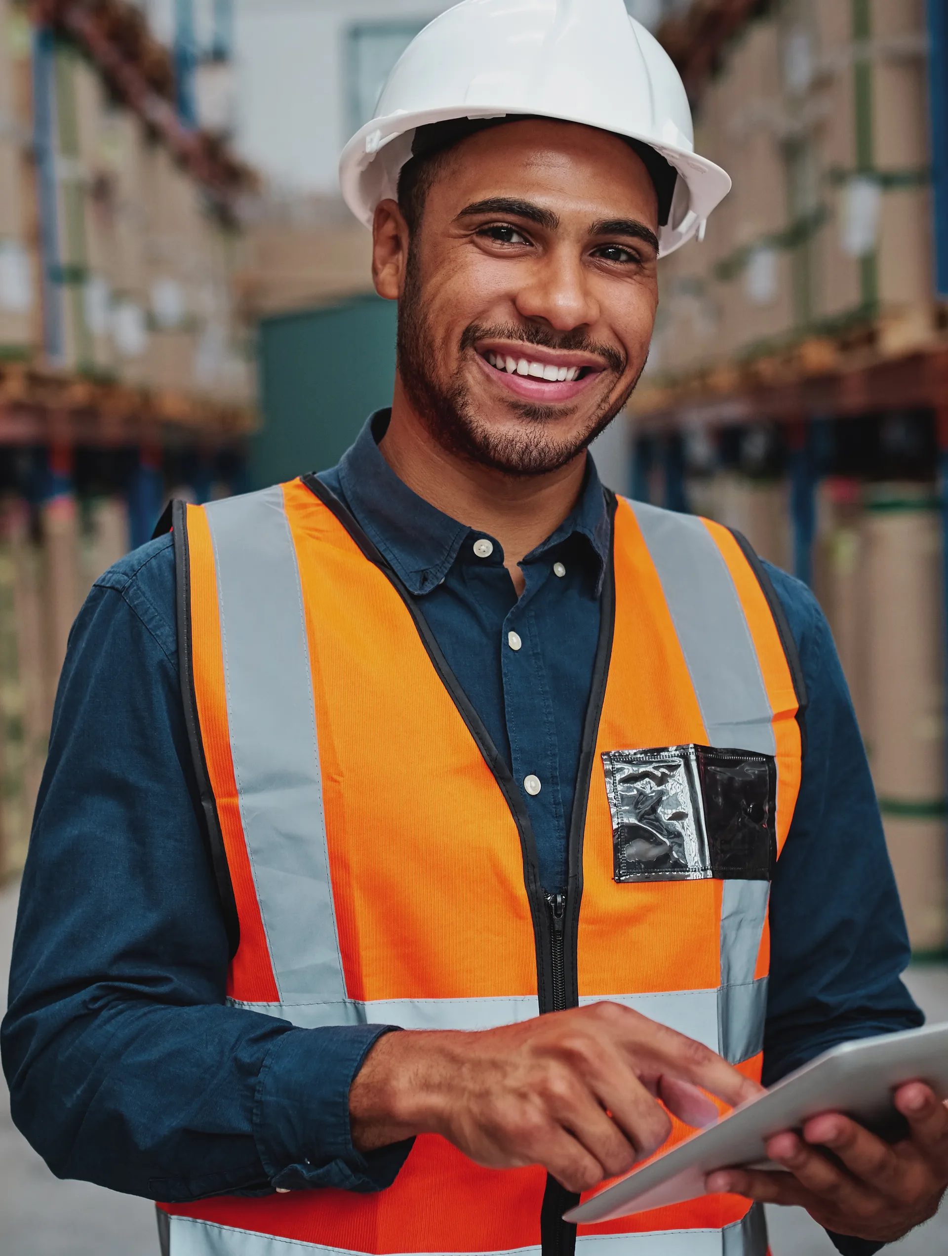 Magazijnmedewerker met helm controleert voorraad op een tablet