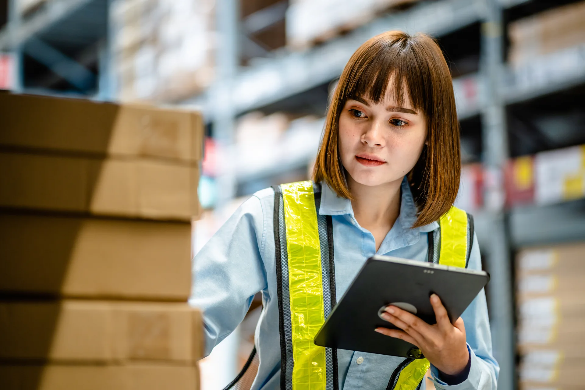 Magazijnmedewerker controleert dozen met een tablet